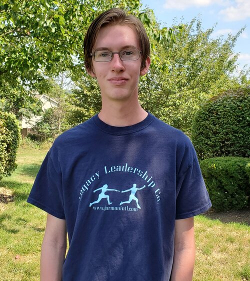 A young man wearing a Legacy Leadership Co. blue t-shirt